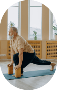 A man with grey hair doing yoga stretch