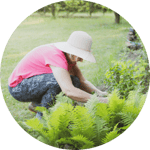 Woman Wearing a Hat Tending to a Garden