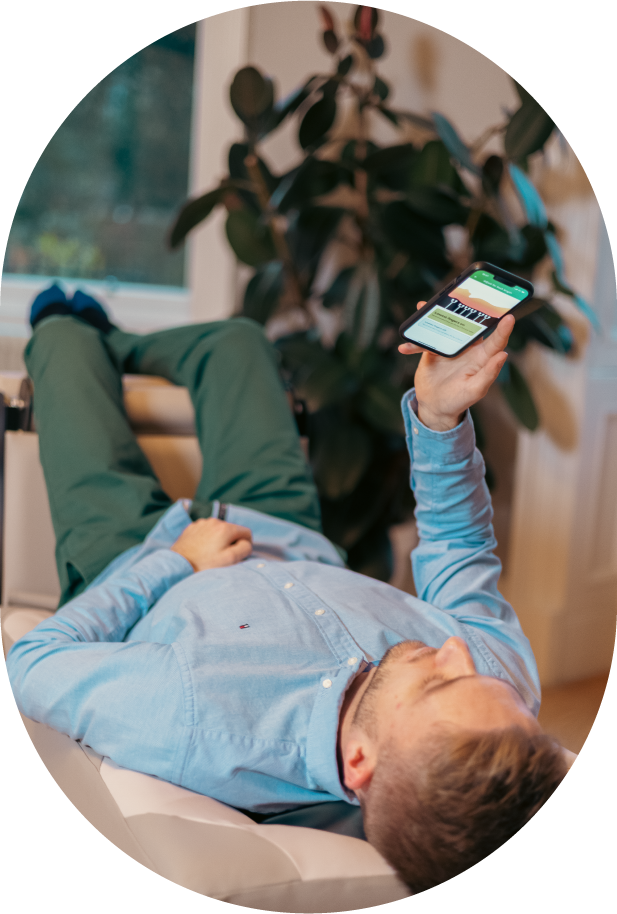 Man laying down on BackHug device and holding phone